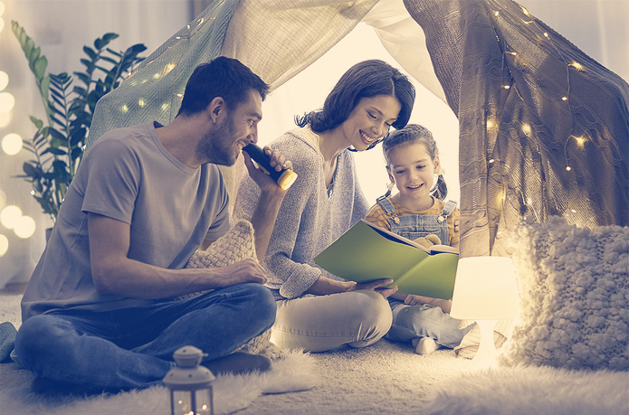 family reading together under tent