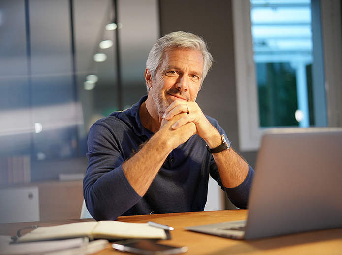 Gray-haired man working at his desk