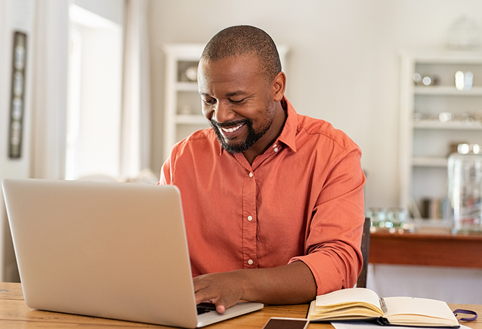 Man working on his computer as his desk